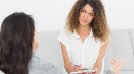 Serious therapist listening to her talking patient